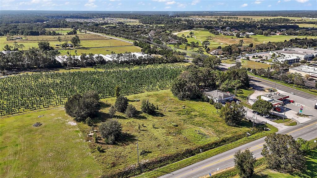 An aerial view shows a vacant lot adjacent to a gas station and agricultural fields — SR-44, SORRENTO, FL