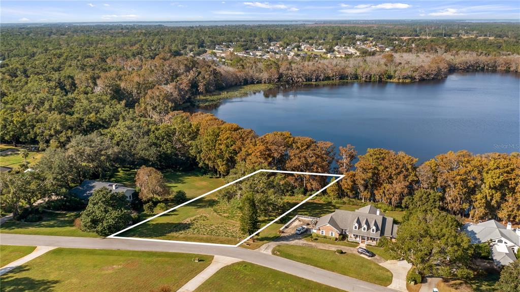 An aerial view shows a vacant, rectangular lot situated between two houses near a lake — LAKE SWATARA DRIVE, EUSTIS, FL