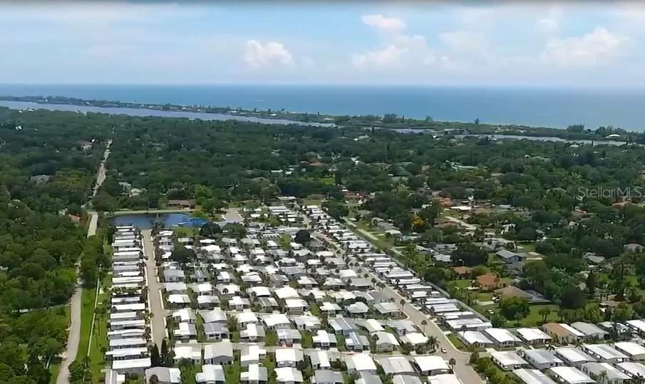An aerial view shows a dense residential neighborhood of mobile homes near a coastal waterway — 5881 SUNFLOWER ROAD, VENICE, FL