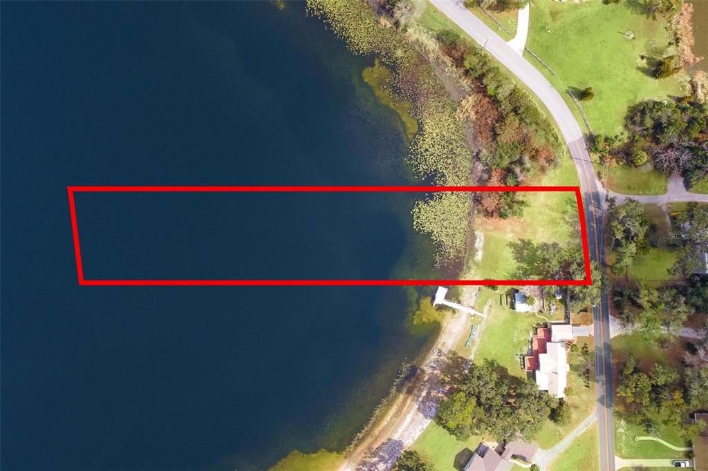 An aerial view shows a rectangular red outline over a vacant waterfront lot — 0 WILSON PARRISH ROAD, UMATILLA, FL