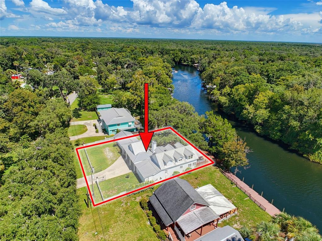 An aerial view shows a house with a metal roof outlined in red near a river — 5415 RIVERSIDE DRIVE, YANKEETOWN, FL