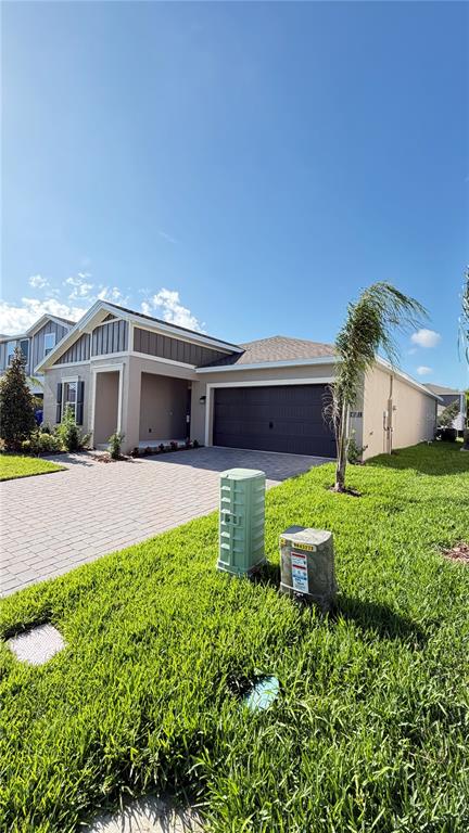 A single-story house with a two-car garage and a paved driveway under a blue sky — 4585 GOLDEN KNIGHT BOULEVARD, KISSIMMEE, FL