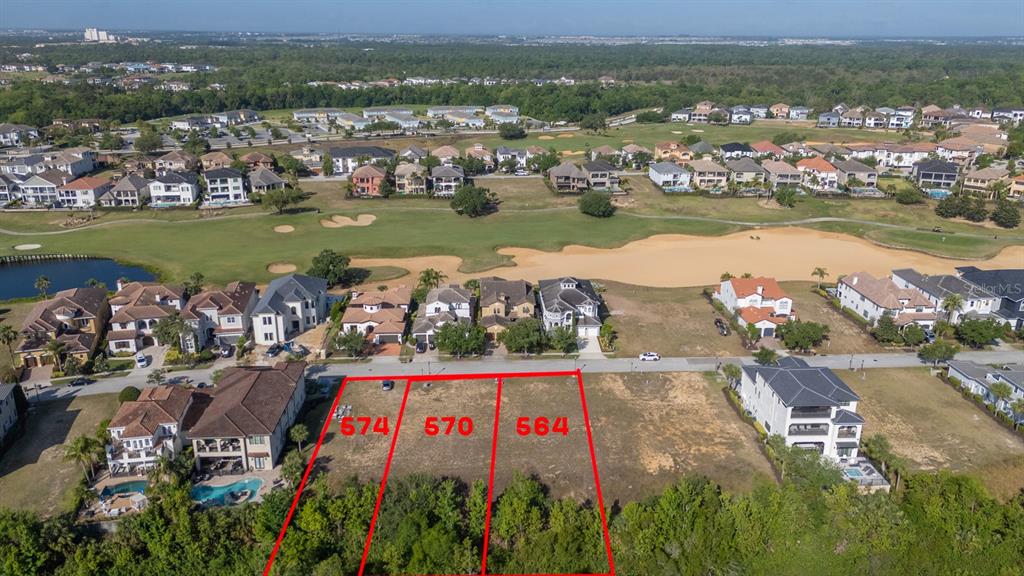 An aerial view shows three vacant residential lots outlined in red alongside existing houses — 564 MUIRFIELD LOOP, REUNION, FL