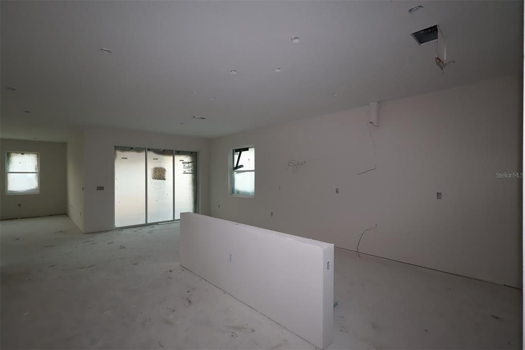An interior view of a house under construction featuring concrete block walls and wooden trusses — 17043 OVERSTORY ROAD, ORLANDO, FL