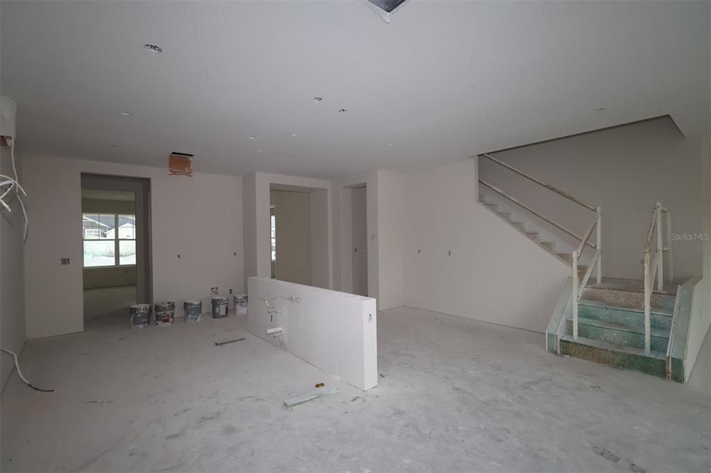 An unfinished room features concrete block walls with vertical furring strips and exposed wooden roof trusses — 17043 OVERSTORY ROAD, ORLANDO, FL