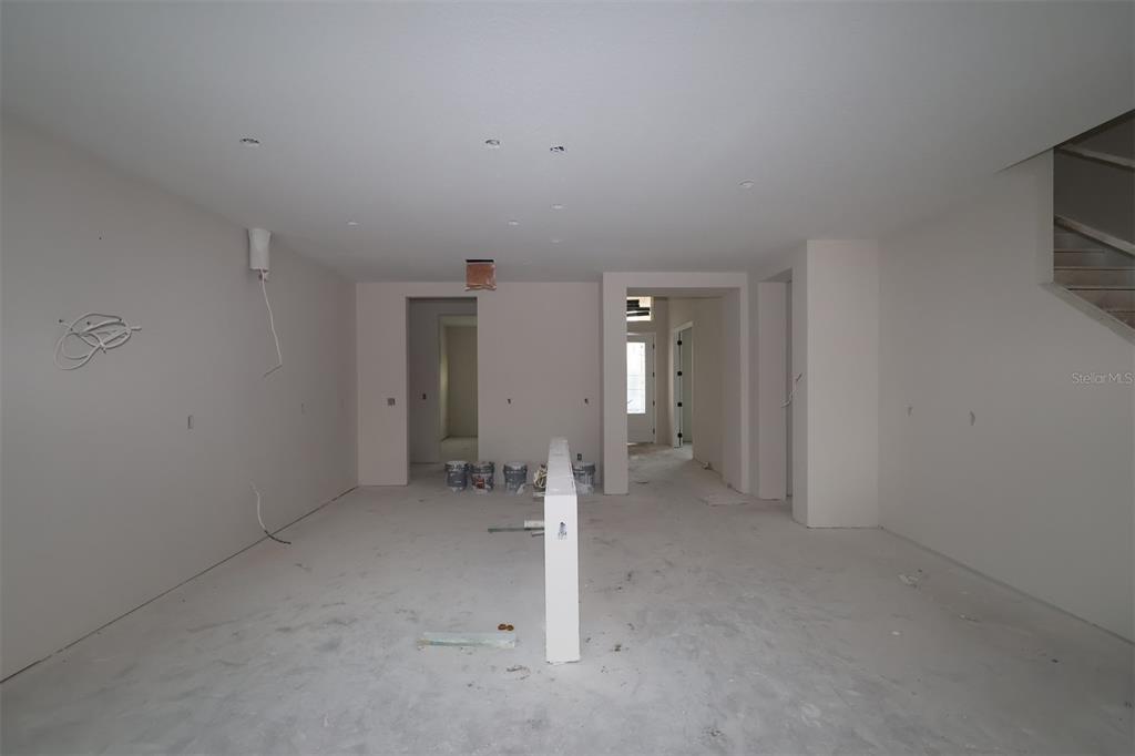 An unfinished room features concrete block walls with green furring strips and exposed wooden roof trusses — 17043 OVERSTORY ROAD, ORLANDO, FL