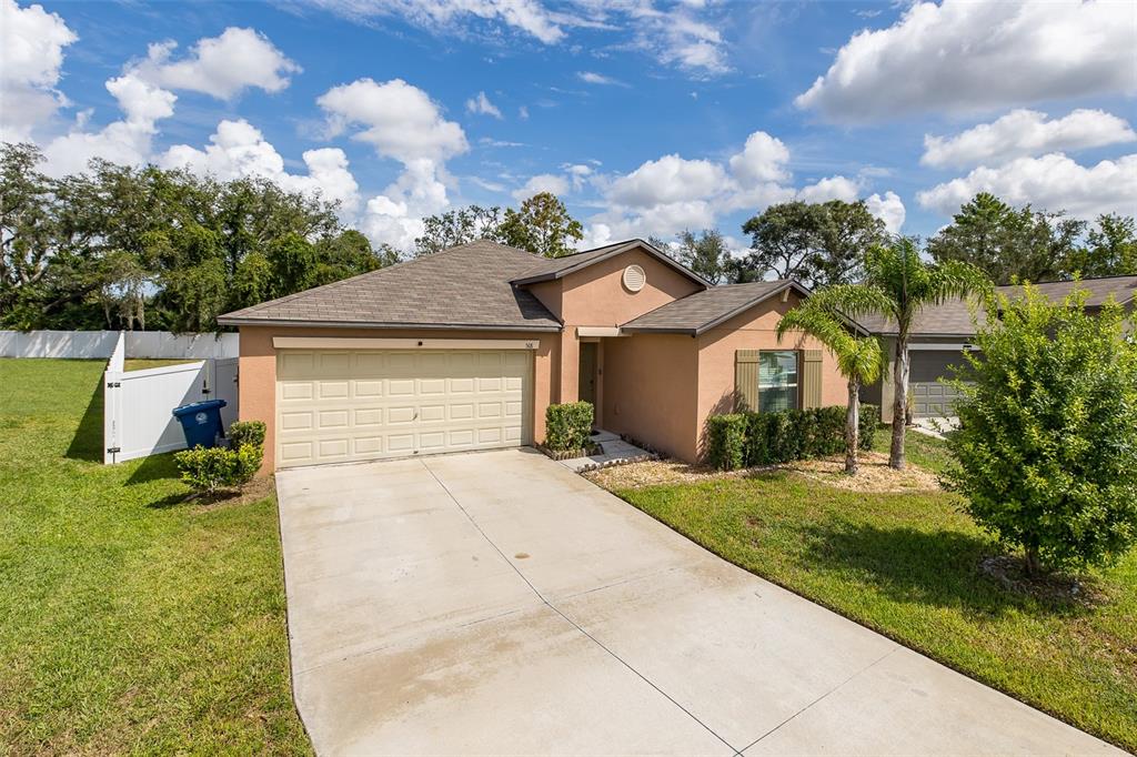 A tan single-story house with a two-car garage and a concrete driveway — 518 ARGYLL DRIVE, SPRING HILL, FL