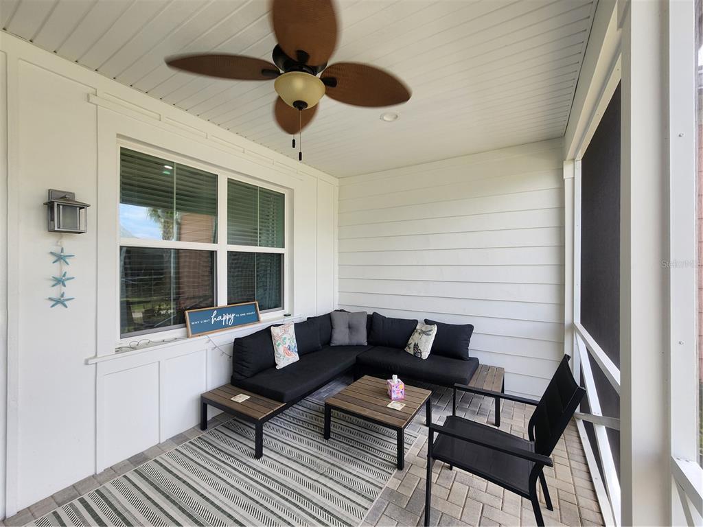 A screened-in porch features a sectional sofa, a coffee table, and a ceiling fan — 218 OCEAN HAMMOCK LOOP, DAYTONA BEACH, FL