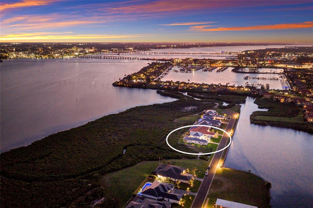 An aerial view shows a house circled in white, situated near a bay and marina — 1517 4TH STREET E, PALMETTO, FL