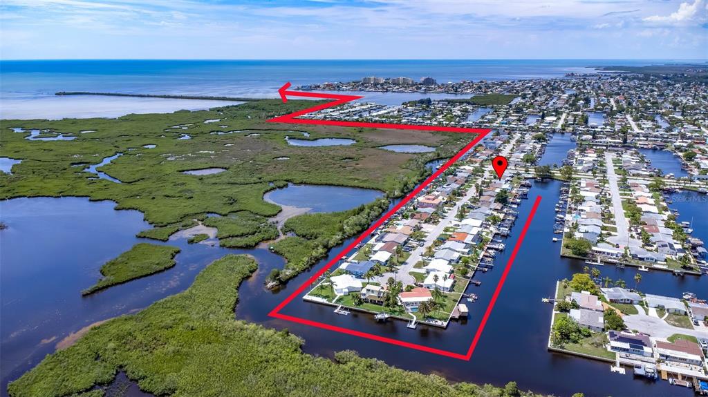 This aerial view shows a residential neighborhood bordering a mangrove marsh and a canal — 12700 5TH ISLE, HUDSON, FL