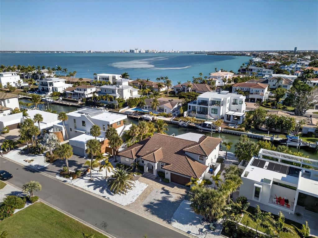 An aerial view of a coastal neighborhood featuring houses with tile roofs and private docks — 562 RANGER LANE, LONGBOAT KEY, FL