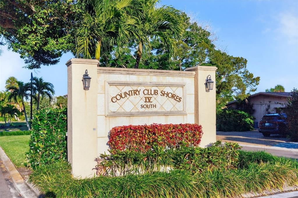 A stone monument sign for Country Club Shores IV South stands in a landscaped area — 562 RANGER LANE, LONGBOAT KEY, FL