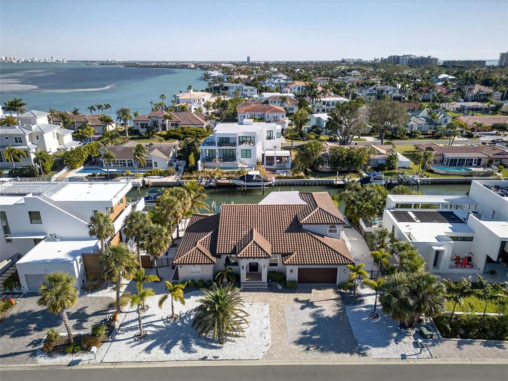 An aerial view of a single-story house with a tiled roof and a waterfront backyard — 562 RANGER LANE, LONGBOAT KEY, FL