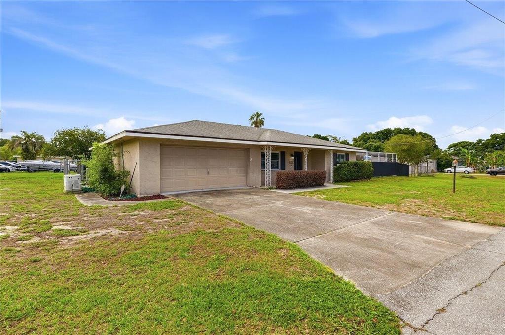 A single-story house with a beige exterior, a two-car garage, and a concrete driveway — 132 DUVAL ROAD, WINTER HAVEN, FL