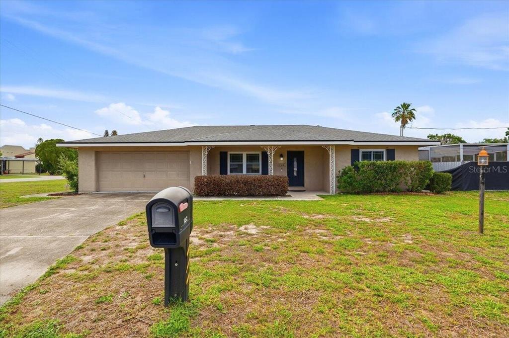 A single-story house with a beige exterior, a two-car garage, and a front lawn — 132 DUVAL ROAD, WINTER HAVEN, FL