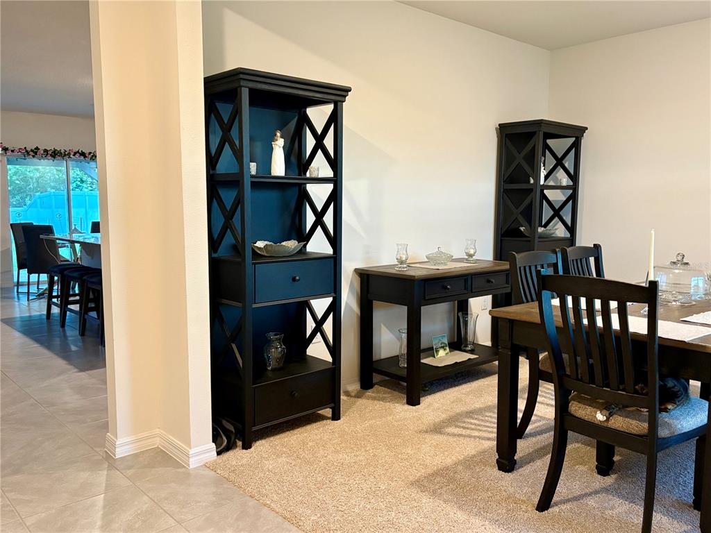 A dining room features black wooden shelving units, a matching console table, and a dining set — 3019 STATEN DRIVE, DELTONA, FL