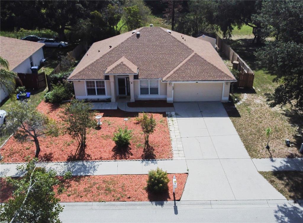 An aerial view of a single-story suburban house with a tan exterior and brown roof — 534 TIMBER RUN LANE, GROVELAND, FL