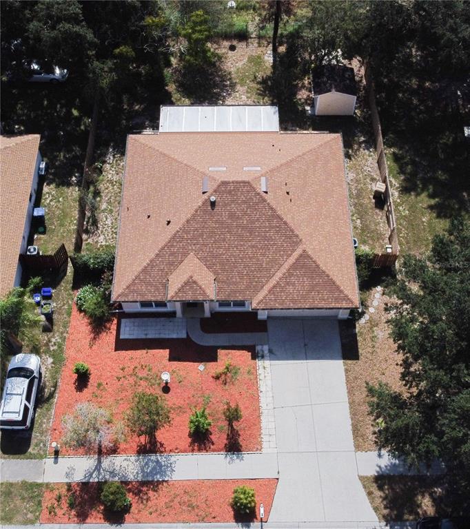 An aerial view shows a single-story house with a brown shingled roof and driveway — 534 TIMBER RUN LANE, GROVELAND, FL