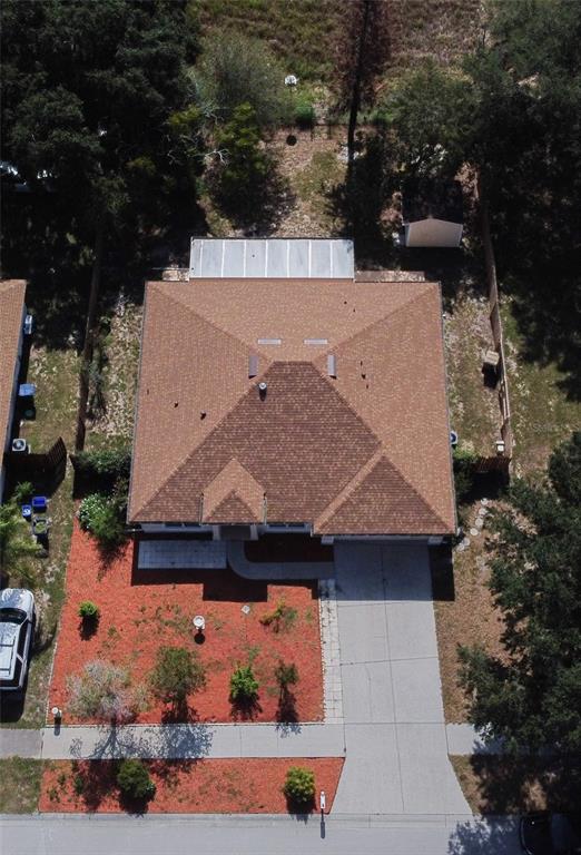 An aerial view shows a single-story house with a brown shingled roof and a driveway — 534 TIMBER RUN LANE, GROVELAND, FL