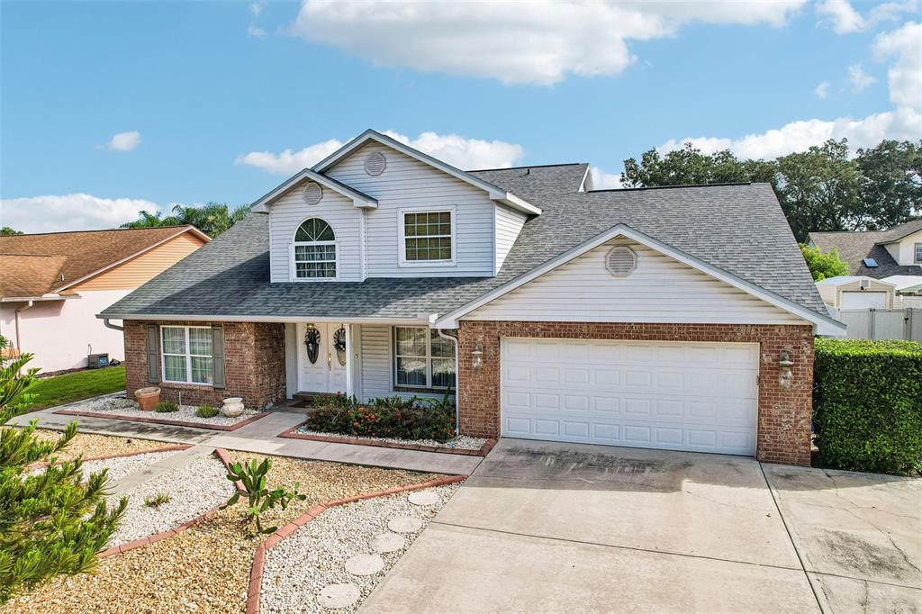 A two-story house with a brick and siding exterior, a garage, and a front yard — 1424 DUMONT DRIVE, VALRICO, FL