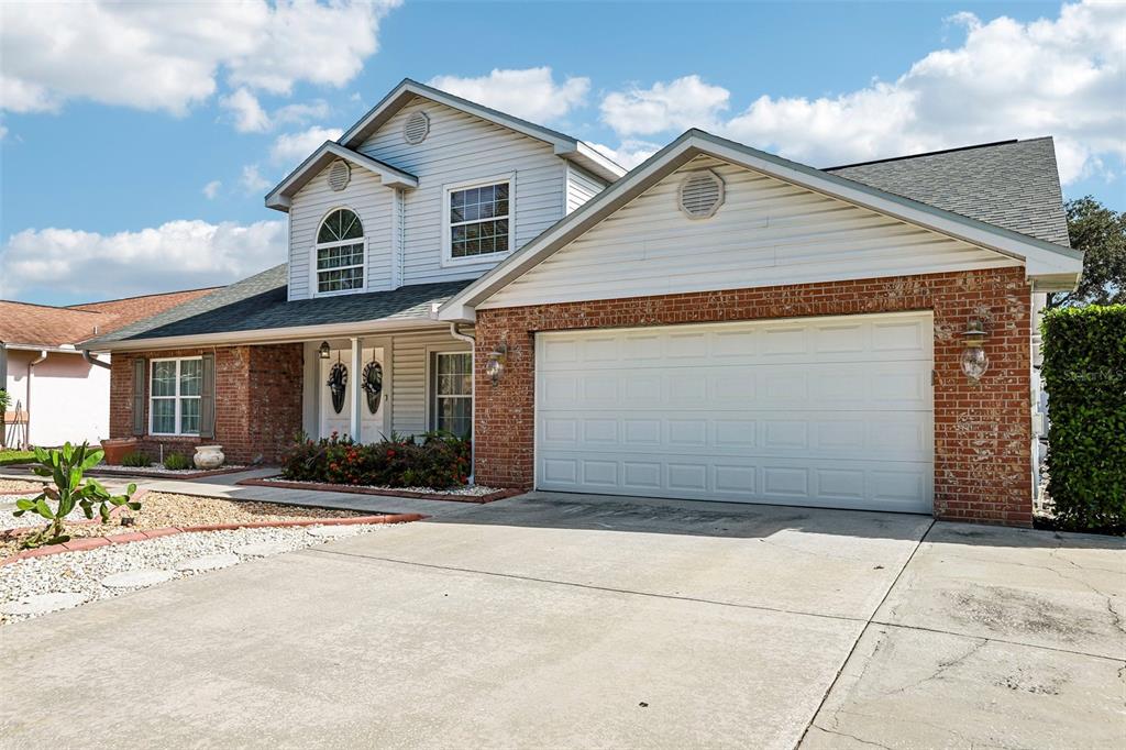A two-story house features a brick and siding exterior with a two-car garage — 1424 DUMONT DRIVE, VALRICO, FL