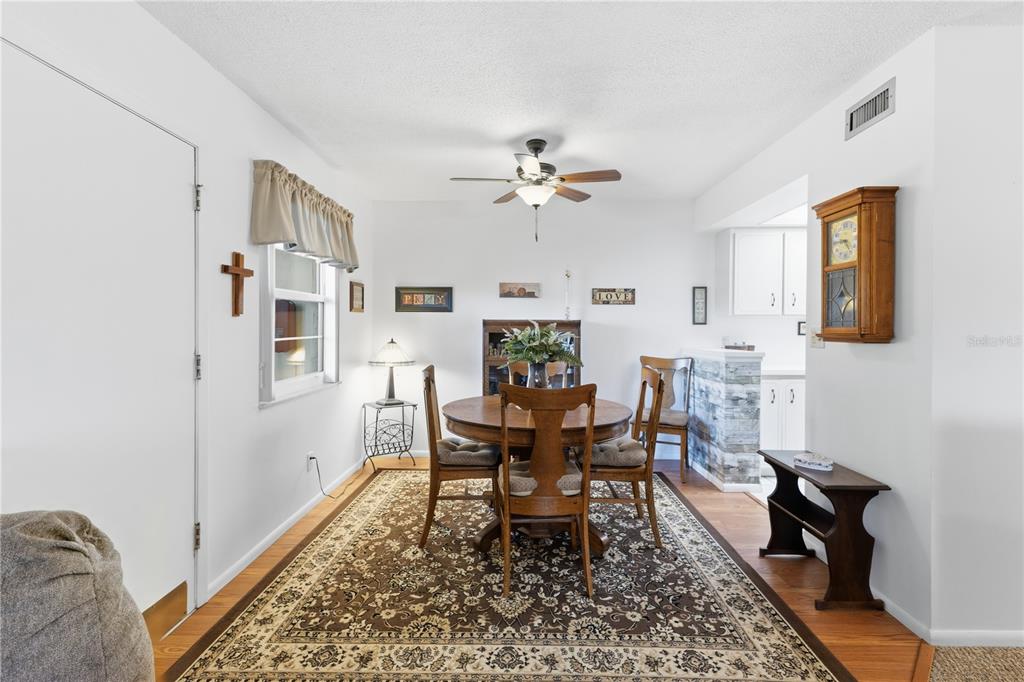 A dining room features a round wooden table, four chairs, and a large patterned area rug — 72 BOUNDARY BOULEVARD UNIT 210, ROTONDA WEST, FL