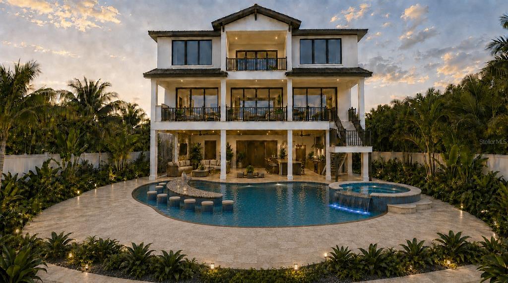 A three-story waterfront mansion features a pool, boat dock, and balconies at sunset — 11245 9TH STREET E, TREASURE ISLAND, FL