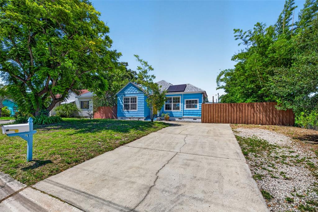 A blue house with a yellow front door and a shingled roof stands on a lawn — 2101 20TH AVENUE N, ST PETERSBURG, FL