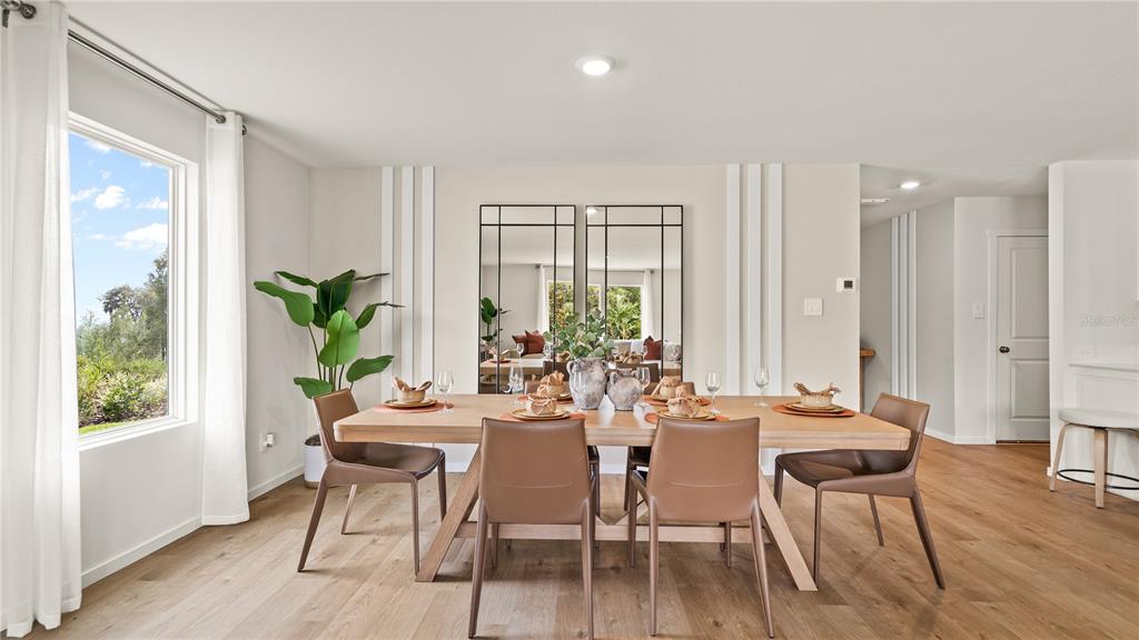 A dining room features a wooden table, leather chairs, large wall mirrors, and light flooring — 331 NOLA LANE, DUNDEE, FL