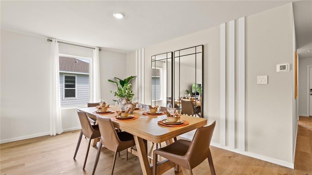 A dining room features a wooden table, leather chairs, and two large wall-mounted mirrors — 331 NOLA LANE, DUNDEE, FL