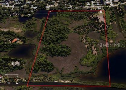 An aerial view shows a rectangular plot of undeveloped land outlined in red — BAY BLVD, PORT RICHEY, FL
