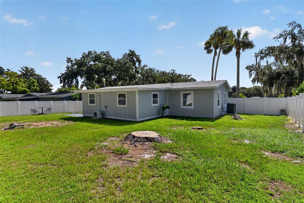 A bedroom with gray walls, light wood-look flooring, a ceiling fan, and an open closet door — 1148 FOUNTAINHEAD DRIVE, DELTONA, FL