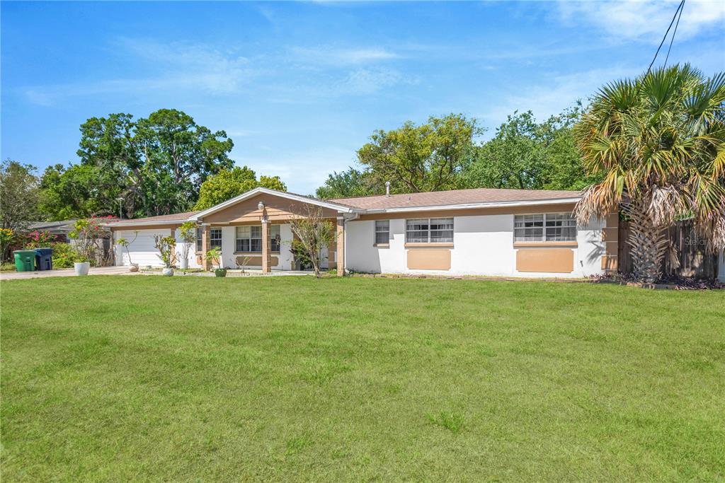A single-story ranch-style house with a white exterior, brown trim, and a large front lawn — 5007 S HESPERIDES STREET, TAMPA, FL