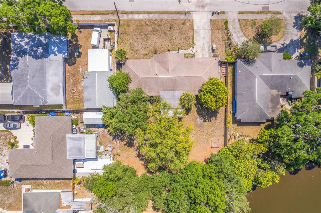 An aerial view shows a residential property with a house, backyard, and waterfront access — 5007 S HESPERIDES STREET, TAMPA, FL