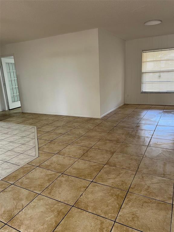 An interior view shows a room with tan tile flooring and white walls — 29 MIAMI DRIVE, LAKE PLACID, FL