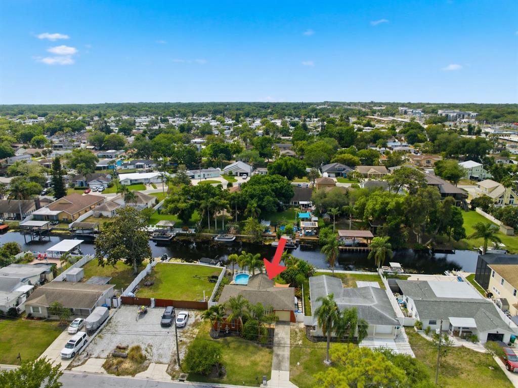 A single-story house with a terracotta-colored exterior, a front fountain, and two palm trees — 51 CYPRESS DRIVE, PALM HARBOR, FL