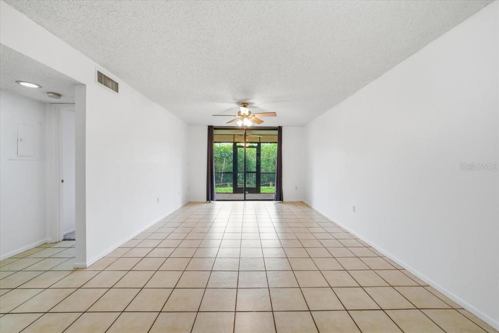 A tan front door with a welcome mat sits on a covered concrete walkway — 1332 PASADENA AVENUE S UNIT 102, SOUTH PASADENA, FL