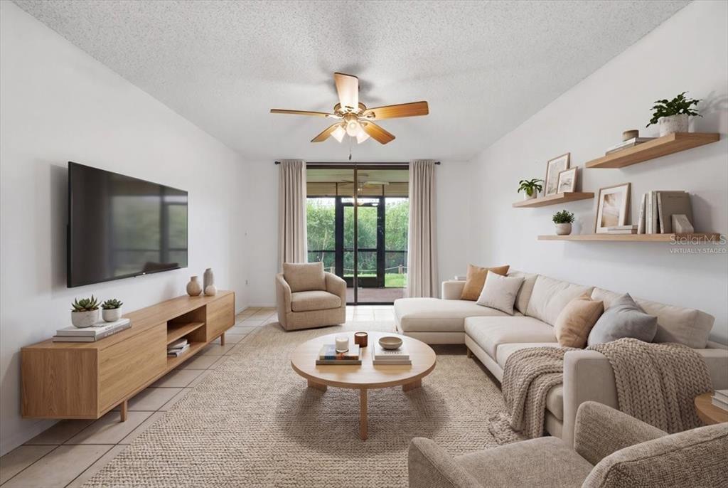 This living room features a television, a sofa, a coffee table, and a ceiling fan — 1332 PASADENA AVENUE S UNIT 102, SOUTH PASADENA, FL