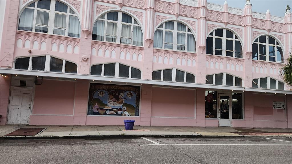 A pink, multi-story commercial building features arched windows and a storefront with a painted mural — 101 W OAK STREET UNIT 101, ARCADIA, FL