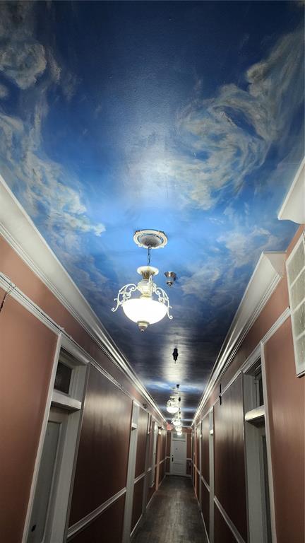 A long hallway with a painted sky ceiling, pendant lighting, and pink-toned walls — 101 W OAK STREET UNIT 101, ARCADIA, FL