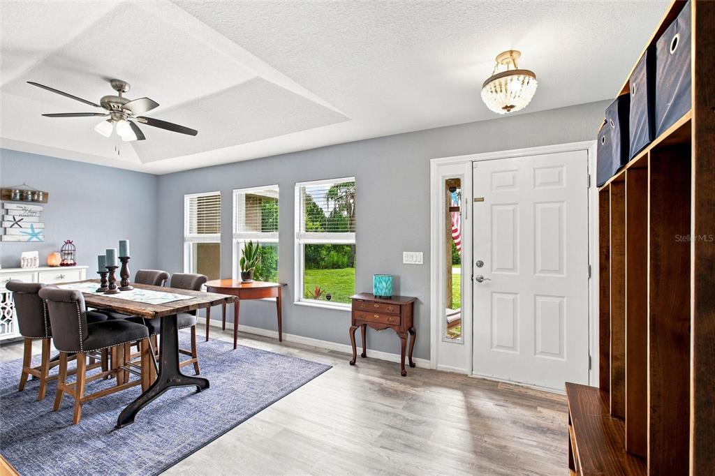 A dining room with a tray ceiling, wood-look flooring, and an adjacent entryway — 2583 PENNSYLVANIA TERRACE, NORTH PORT, FL