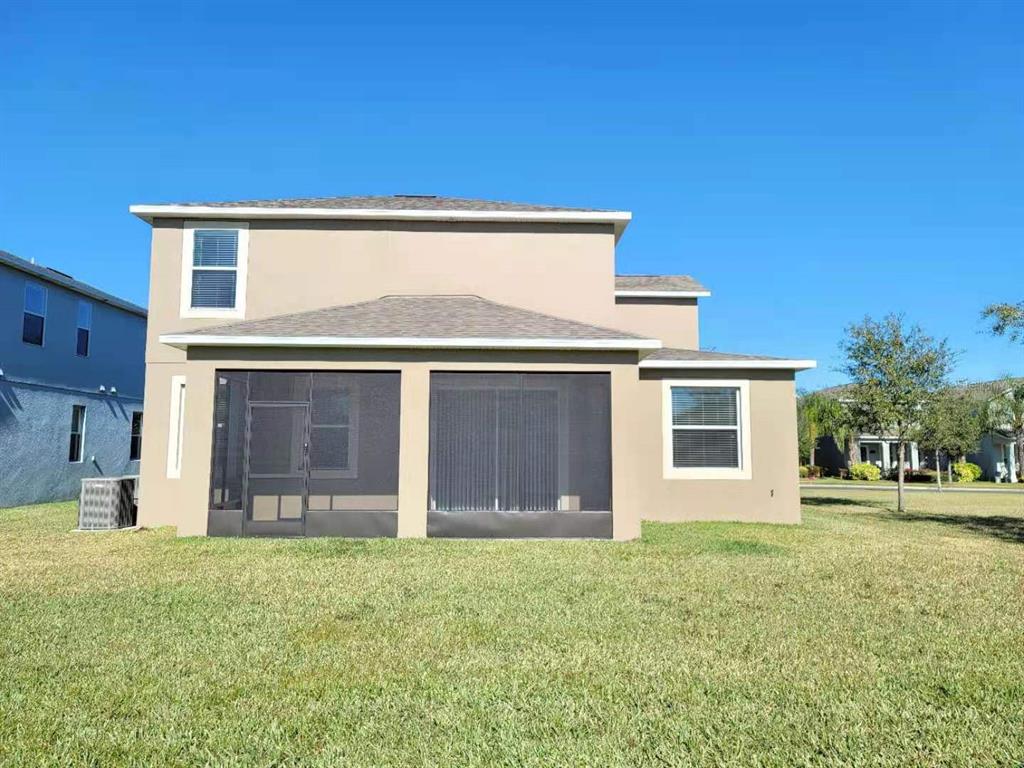 The exterior rear view of a two-story house features a screened-in patio and lawn — 15030 EVERGREEN OAK LOOP, WINTER GARDEN, FL