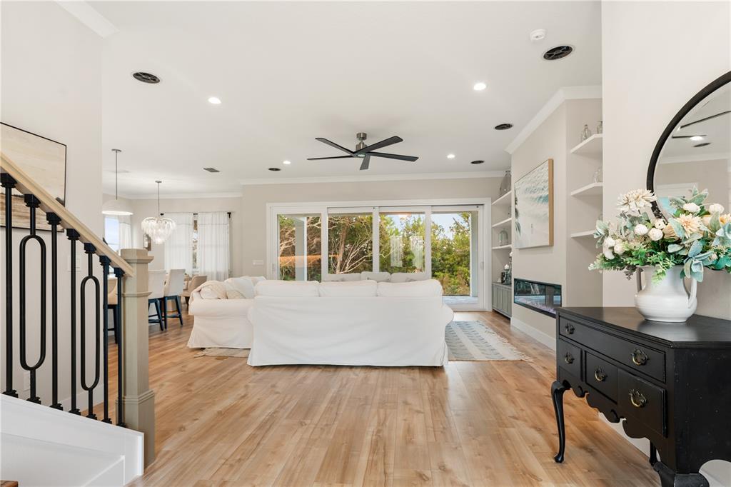 A bright living room features light wood flooring, a white sofa, and a black console table — 2549 PALM AVENUE, FLAGLER BEACH, FL