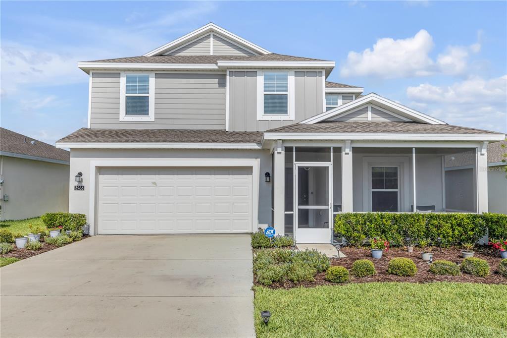 A two-story house with a gray exterior, a two-car garage, and a screened front porch — 3986 WILLOWBROOK DRIVE, EDGEWATER, FL