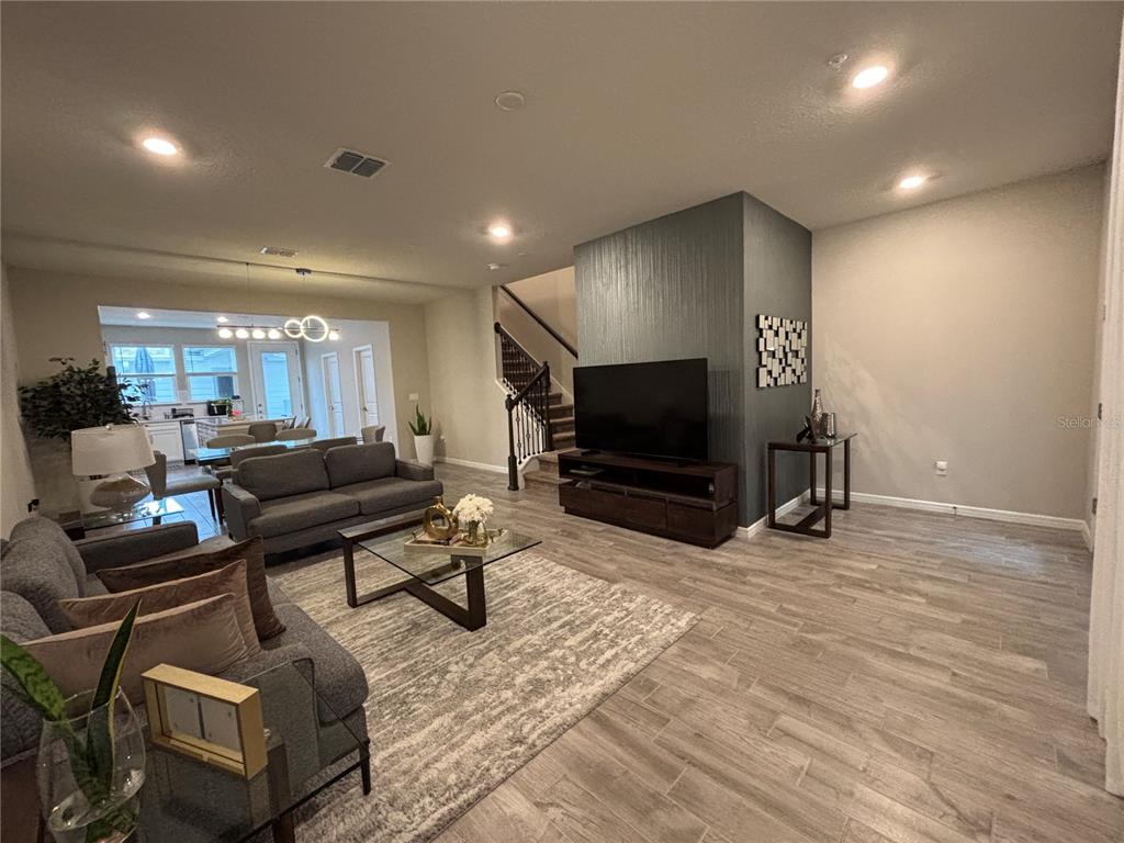 A living room features gray tile floors, a dark accent wall, and an open floor plan — 14550 ORCHID ISLAND DRIVE, ORLANDO, FL