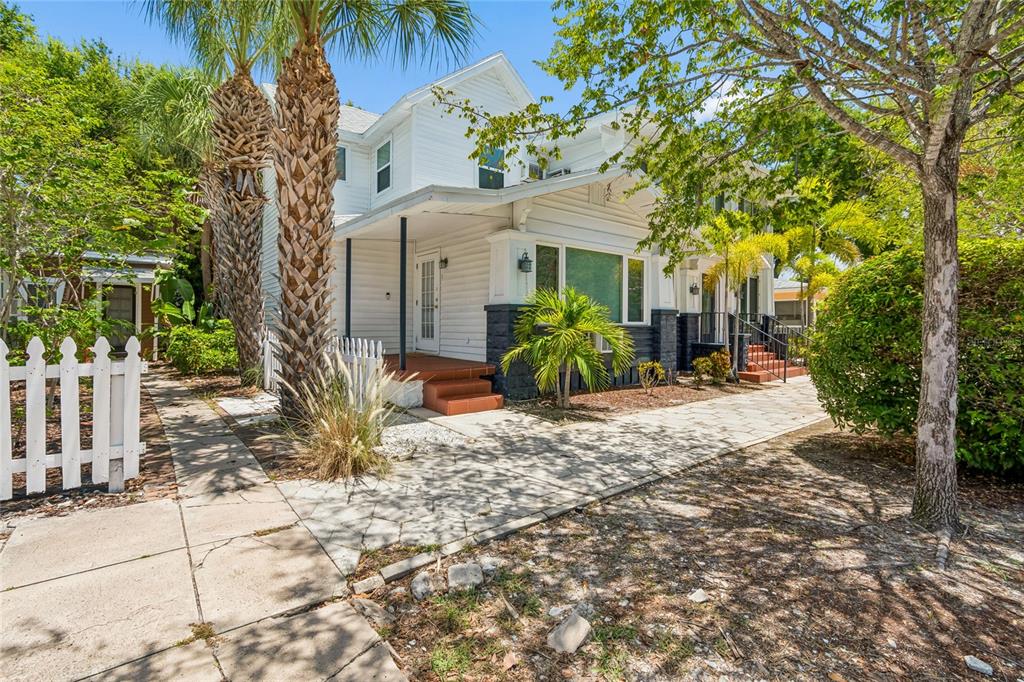 A white two-story house features a wooden deck with a weight bench and palm trees — 255 6TH AVENUE N, ST PETERSBURG, FL