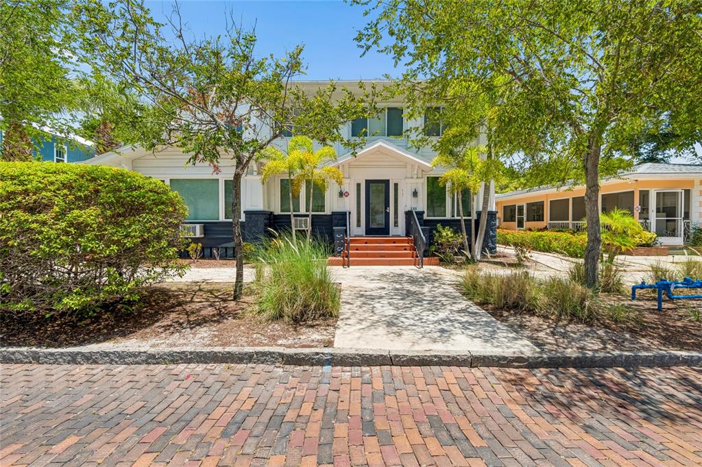 Exterior view of a white house with multiple electrical meters and a stone walkway — 255 6TH AVENUE N, ST PETERSBURG, FL