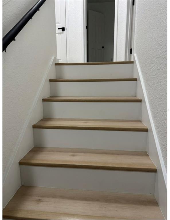 A staircase with light wood treads and white risers leads to a doorway — 16320 PARKSTONE PALMS COURT, TAMPA, FL