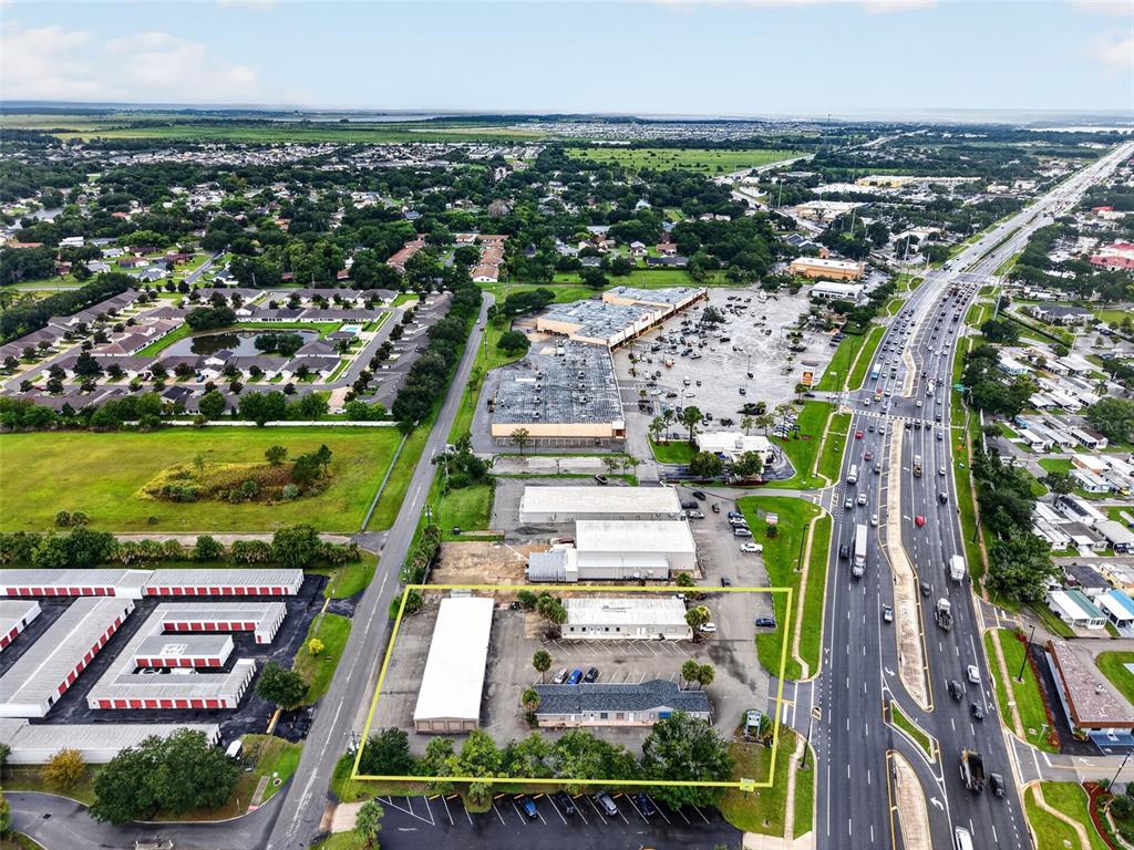 An aerial view shows a commercial property outlined in yellow next to a busy highway — 3207 13TH STREET, ST CLOUD, FL