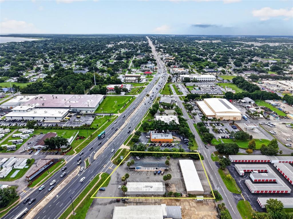 An aerial view shows a commercial property with three buildings outlined in yellow near a highway — 3207 13TH STREET, ST CLOUD, FL
